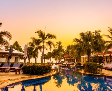 Beautiful luxury umbrella and chair around swimming pool in hotel resort at Sunset times - Vintage Filter and Boost up Color Processing